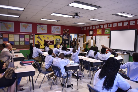 Secretary Johnson joins a classroom at a desk at Kipp Ways Academy