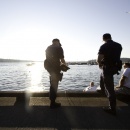Security team members talk with locals on a pier.