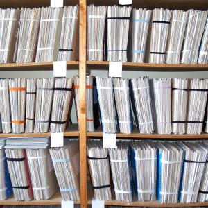 Paper files on a shelf.