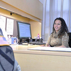 Servicemember speaking with counselor at her desk