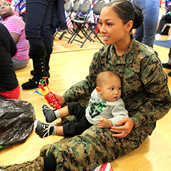 A female service member sitting with her son and playing