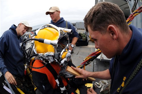 NORTH SEA - Navy Diver 1st Class Travis Bourne, assigned to Mobile Diving and Salvage Unit (MDSU) 2, checks the standby diver for leaks during diving operations from the Military Sealift Command rescue and salvage ship USNS Grasp (T-ARS 51). MDSU-2 and Navy archeologists, scientists, and historians are in the North Sea conducting diving operations verifying the sites of suspected shipwrecks. The researchers hope to find USS Bonhomme Richard, the historic ship commanded by John Paul Jones. (U.S. Navy Photo by Mass Communication Specialist 1st Class Ja&#39;lon A. Rhinehart/RELEASED)