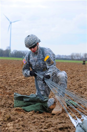 REES, Germany &mdash; A soldier with the 21st Theater Sustainment Command&#39;s 5th Quartermaster Detachment gathers the cords from his parachute in preparation for packing it up after jumping from a C-130 Hercules during the 65th Anniversary of Operation Varsity here, March 27. More than 16,000 paratroopers and several hundred aircraft were involved in the original assault in 1945. (U.S. Army photo by Staff Sgt. Michael J. Taylor)