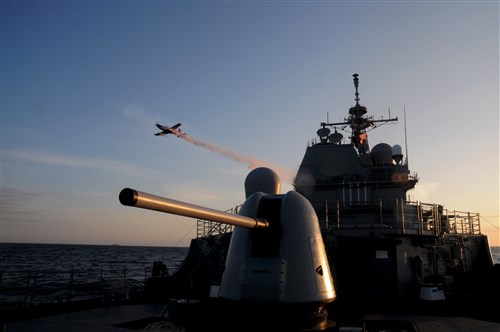 USS NORMANDY, Baltic Sea - An aircraft flies over the Ticonderoga-class guided-missile cruiser USS Normandy (CG 60) simulating a chemical attack, June 5, as part of the Baltic Operation (BALTOPS) exercise 2012. This is the 40th iteration of BALTOPS, a maritime exercise intended to improve interoperability with partner nations by conducting realistic training at sea with 12 participating nations. 