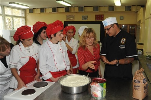 BURGAS, Bulgaria (Oct. 26, 2011) - Culinary Specialist 2nd Class Eber Barraza explains to Bulgarian culinary students how to make cherry turnovers, during a community service project at the Burgas High School. Philippine Sea is on a regularly scheduled deployment in the Black Sea and serves to promote peace and security in the U.S. 6th Fleet area of responsibility. 