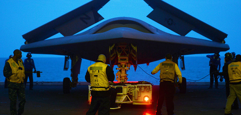 An X-47B Unmanned Combat Air System demonstrator is towed into the hangar bay of the aircraft carrier USS George H.W. Bush (CVN 77), May 13, 2013. (U.S. Navy photo by Mass Communication Specialist 2nd Class Timothy Walter/Released)
