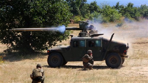 U.S. Marine Lance Cpl. Gordon Kwei, anti-tank missile man with Weapons Company, Black Sea Rotational Force, fires the tube-launched, optically tracked, wire-guided anti-tank missile (TOW), while Staff Sgt. Wayne Edmiston, combat correspondent with Black Sea Rotational Force, records it during the combined anti-armor team sustainment training for Exercise Platinum Lion 15-3, July 8 at Novo Selo Training Area, Bulgaria. The Marines launched 10 TOW missiles fired from M41 Sabers mounted to the turrets of Humvees.  Marines with Black Sea Rotational Force and service members from Bulgaria, Romania, the United Kingdom and Albania are conducting the two-week exercise to promote regional cooperation and foster interoperability in order to combat security threats. (U.S. Marine Corps photo by 1st Lt. Sarah E. Burns)