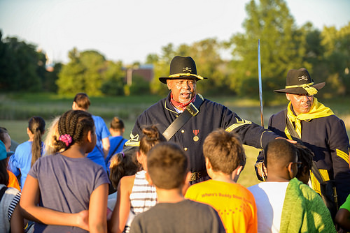 A member of the Buffalo Soldiers of the American Northwest talking to fourth graders