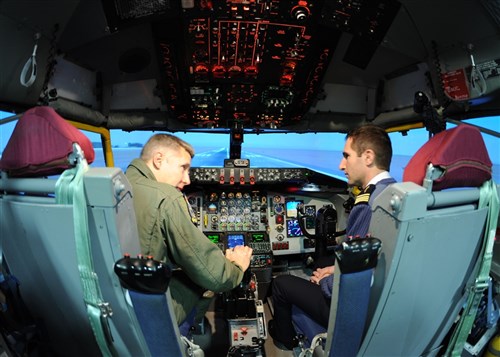 RAF MILDENHALL, England – Lt. Col. Robert Ricks, 100th Air Refueling Wing director of staff, shows French air force Maj. Sebastien Pages the cockpit of a KC-135 Stratotanker aircraft flight simulator here Jan. 5, 2012. A group of French airmen visited the base as part of efforts to maintain and strengthen U.S. and French air force working relationships. 