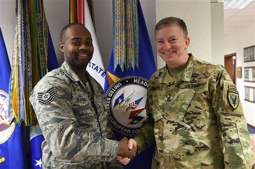 U.S. European Command Deputy Commander Lt. Gen. W. Burke Garrett III presents a coin to Tech. Sgt. Dwayne Blandin, Emergency Actions Controller, for outstanding duty performance Apr. 15, 2016.
