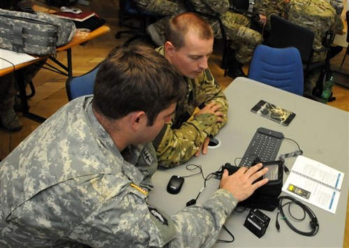 STUTTGART, Germany ~~ A U.S. military intelligence noncommissioned officer assigned to 1st Battalion, 10th Special Forces Group (Airborne), left, demonstrates how to use the Secure Electronic Enrollment Kit to an intel officer assigned to the Poland Special Operations Command during a training engagement sponsored by U.S. Special Operations Command Europe Aug. 11 at Panzer Barracks. The engagement is part of SOCEUR's mission to increase the SOF interoperability and capability of partner nations within European Command's area of responsibility. (U.S. Army photo by Master Sgt. Donald Sparks)