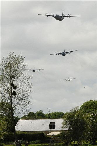 Two C-130Hs, one C-130J and one German C-160 fly by the crowd in Saint Mere-Eglise, France June 3. The transport aircraft were used to hold parachutists who jumped out of the aircraft in a way to pay homage to the paratroopers who died in service to their country 68 years ago in Normandy.