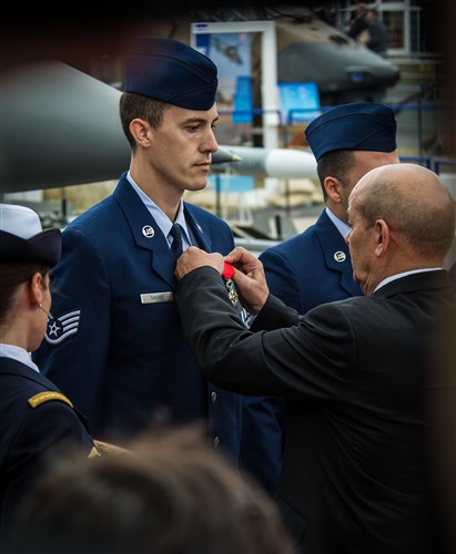 French Minister of Defence Jean Yves Le Drian pins the French Legion of Honor medal on Staff Sgt. Greggory Swarz at Le Bourget Airport during the International Paris Air Show, June 15, 2015. Swarz was recognized for his heroic actions on Jan. 26, 2015, when he saved the lives of three French airmen after a Hellenic air force F-16 Fighting Falcon crashed into the parking ramp at Los Llanos Air Base, Spain, during Tactical Leadership Program 15-1. Swarz is a 492nd Aircraft Maintenance Unit electrical environmental systems specialist assigned to RAF Lakenheath, U.K. (U.S. Air Force photo/ Tech. Sgt. Ryan Crane)
