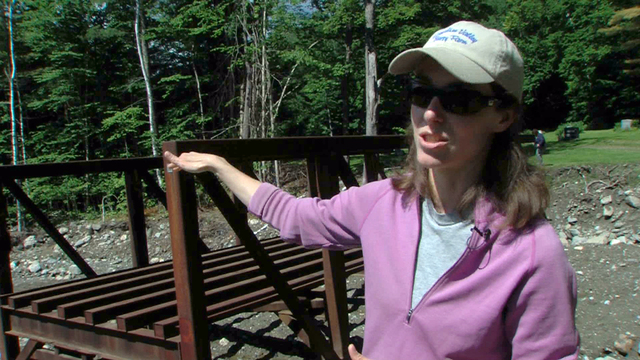 Rochester, Vt., July 25, 2012 -- White River Partnership Executive Director Mary Russ explains how a bridge she reclaimed from a salvage yard will be recycled to be used as a replacement for a culvert that was impacted by Tropical Storm Irene. The bridge will replace a culvert in the Woodlawn Cemetery in Rochester, Vermont.