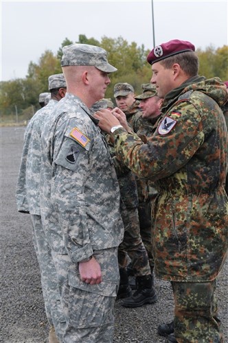 WILDFLECKEN, Germany (Oct. 20, 2011) -- Lt. Col. Anselm Stark (right), commander, German Army Signal Battalion for Air Mobile Division, places a unit pin onto Capt. Richard Hagner, 72nd Expeditionary Signal Battalion, during Exercise Express 11. The exercise is a demonstration of the German Army Air Mobile Division's ability to execute disaster relief and build partnership capabilities between German and American armed forces.