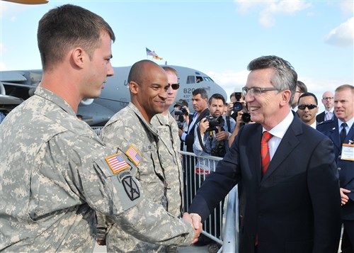 BERLIN - Thomas de Maiziere, German Defense Minister, greets Army Sgt. Michael Allen, Joint Multinational Readiness Center Falcons UH-72A Lakota production control NCO and crew chief, Hohenfels, Germany, at Berlin Air Show, commonly known as ILA 2012, here, Sept. 13, 2012. The air show is an international event hosted by Germany and more than 50 U.S. military personnel from bases in Europe and the United States are here to support the various U.S. military aircraft and equipment on display. The U.S. military aircraft featured at ILA 2012 are the UH-60 Black Hawk, UH-72A Lakota, F-16C Fighting Falcon, C-17 Globemaster III, and C-130 Hercules.