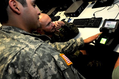 A U.S. military intelligence noncommissioned officer assigned to U.S. Special Operations Command Europe, left, demonstrates how to use the Secure Electronic Enrollment Kit to an intel noncommissioned officer assigned to the Slovakian 5th Special Forces Regiment during an intel-focused program of instruction sponsored by SOCEUR Oct. 18 at Patch Barracks, Germany. The Partner Development Program engagement is part of SOCEUR's mission to increase the SOF interoperability and capability of partner nations within U.S. European Command's area of responsibility. 