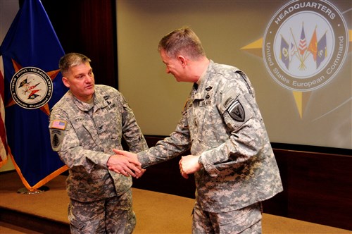 U.S. European Command Deputy Commander Lt. Gen. William Garrett III presents a coin to U.S. Army Col. John Stack, Stuttgart Garrison Commander, for his support of EUCOM's personnel and mission.