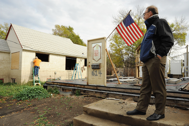 David Myers, Director of the DHS Center for Faith-based and Neighborhood Partnerships, stands by the steps and door front remains of a flooded Minot home.