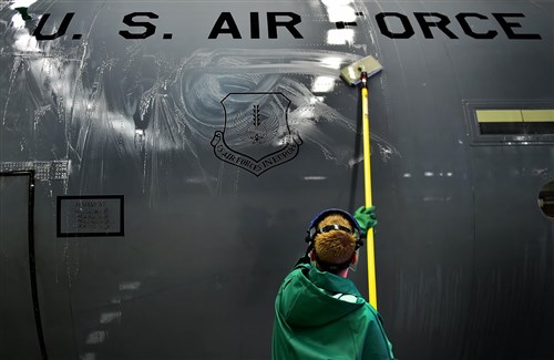 An Airman from the 86th Aircraft Maintenance Squadron washes the fuselage of a C-130J Super Hercules cargo aircraft April 20, 2015, at Ramstein Air Base, Germany. Aircraft washing is a vital part of the flying mission, and if not washed regularly, aircraft begin to corrode and cause damage yielding it unsafe to operate. Safety procedures require all members participating in the washing to wear full-body protective gear. (U.S. Air Force photo/Staff Sgt. Sara Keller)