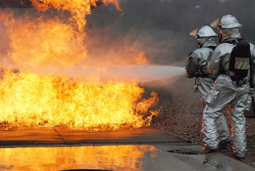 WOENSDRECHT AIR BASE, The Netherlands &mdash; Airmen in the 309th Airlift Squadron extinguish a flare up below an aircraft&#39;s wing during a training exercise at the Woensdrecht Firefighting Training Facility in the Netherlands. (Department of Defense photo by Christie Vanover)