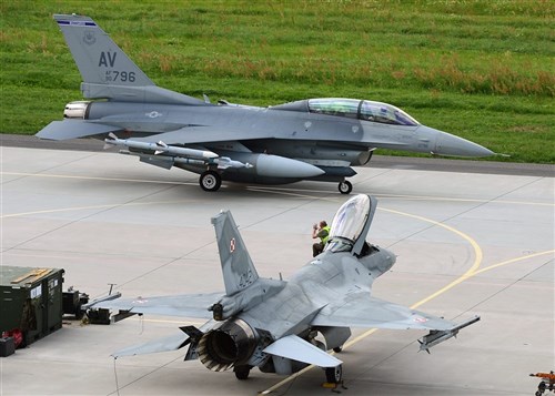 One crew chief waves to another during the beginning of a familiarization flight in Poland. Six aircraft from the 31st Fighter Wing, Aviano Air Base, Italy, deployed to Poland as part of a partnership-building event July 15-26, 2013.