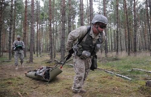 Petty Officer 3rd Class Toby League, a Navy Corpsmen from Naval Support Activity Naples, Italy and a candidate for the 2011 U.S. Army Europe Expert Field Medical Badge Standardization and Testing, pull a casualty through the woods during part of Combat Lane 3 on Aug. 3, 2011 at the Grafenwoehr Training Area, Germany. League is one of a handful of joint and multinational service members working toward the U.S. Army medical community's most prestigious professional badge. (U.S. Army photo by Spc. Trisha Pinczes)