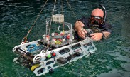 A U.S. Navy diver helps the Amador Valley High School, Pleasanton, CA, vehicle enter the water at the 18th Annual International RoboSub Competition at the Space and Naval Warfare Systems Center Pacific. (Photo by Alan Antczak/Released)