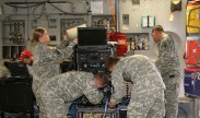 Soldiers configure the communications systems housed within ruggedized transit cases to allow in-flight secure network access and mission command for increased situational awareness, as part of the Enroute Mission Command Capability (EMC2) demonstration on May 14, 2015 at Pope Army Air Field, Fort Bragg, N.C. (U.S. Army photo by Amy Walker, PEO C3T)