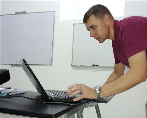 U.S. Air Force Maj. Steve Payne, Intelligence, Surveillance, Reconnaissance mission planning instructor from U.S. Air Forces in Europe and Air Forces Africa, tests his laptop for operations in Atar, Mauritania prior to starting a class where airmen from six African nations will learn about ISR mission planning during African Partnership Flight, Aug. 30, 2014. APF is the premier program for building aviation capacity, enhancing regional cooperation, and increasing U.S. and African interoperability. (U.S. Air Force photo/Master Sgt. Brian Boisvert)