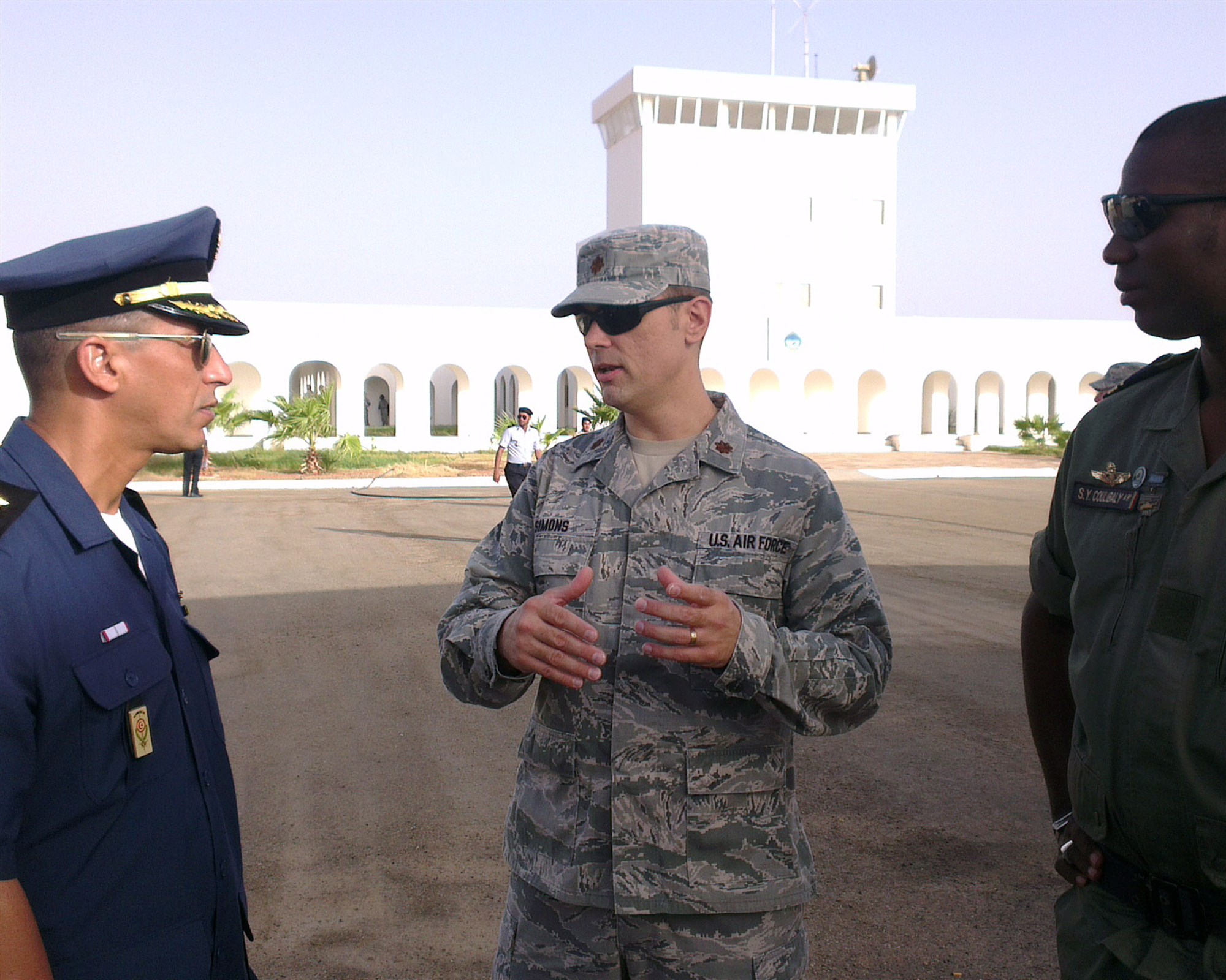 U.S. Air Force Maj. Michael Simons, African Partnership Flight Mauritania team lead, speaks with Tunisian Air Force Maj. Karim Boukara, instructor pilot, and Mali Air Force Maj. Soliba Yacouba Coulibaly, helicopter instructor pilot, before the start of the second day of APF Mauritania at Atar Airbase, Mauritania Sept. 1, 2014. A team of more than 50 students from six African nations are taking part of this APF with a combined goal to increase aviation capacity, enhance regional cooperation and increase interoperability. (U.S. Air Force photo/Master Sgt. Brian Boisvert)