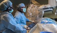 Maj. Ryan McDonough (background), chief of cardiology, William Beaumont Army Medical Center, inserts a guide wire through the femoral artery of a patient during an ST- Segment Elevation Myocardial infarction, or STEMI, procedure at the catheterization laboratory, WBAMC, June 29. WBAMC currently holds the fastest door-to-balloon times in the Department of Defense and the City of El Paso, Texas, averaging 50 minutes over the last two years. Door-to-balloon time is the measurement of time necessary from the point of patient arrival to the point a catheter with a small balloon is deployed placing a coronary stent system in the artery and opening up the artery. National guidelines for door-to-balloon time are set at 90 minutes or less.