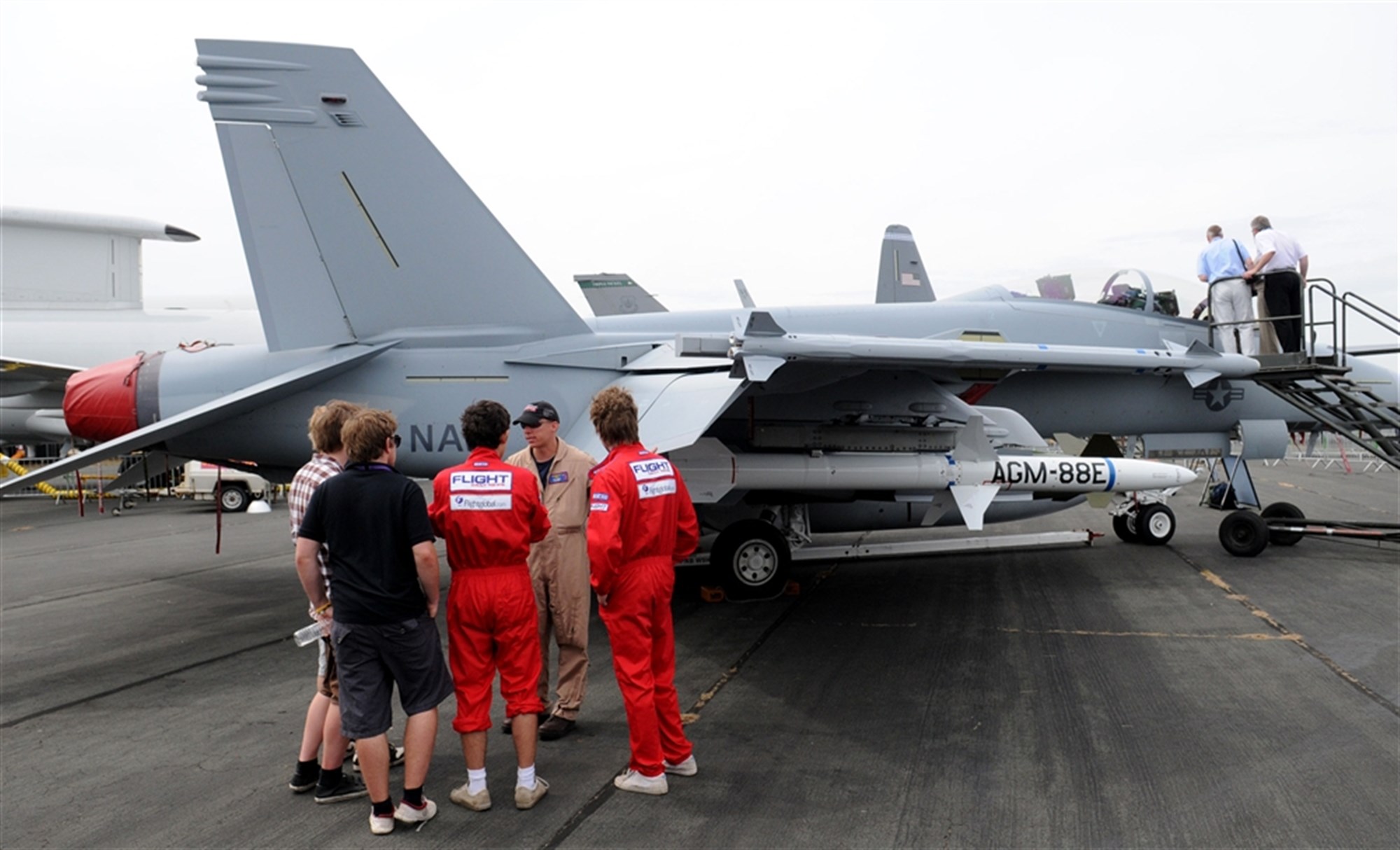 FARNBOROUGH, United Kingdom &mdash; Navy Lt. Ray Bieze, F/A-18F pilot, Air Test and Evaluation Squadron Two Three, Naval Air Station Patuxent River, Md. tours a group of aviation enthusiasts around an F/A-18F Super Hornet during the Farnborough International Air Show July 20. Lieutenant Bieze explained the different areas around the aircraft and capabilities of the Super Hornet to the group. (U.S. Air Force photo by Staff Sgt. Jerry Fleshman)