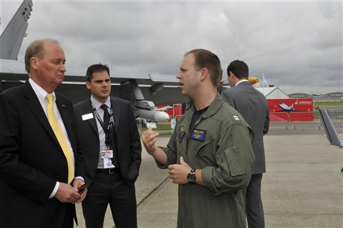 U.S. Navy Lt. Adam Farber, Strike Fighter Weapons School Pacific weapons system officer, discusses his experience with the weapons on an F/A-18E Super Hornet with Rick Yuse Raytheon Space and Airborne Systems president, July 10, 2012, during the Farnborough International Air Show in Farnborough, England. Approximately 90 aircrew and support personnel from bases in Europe and the United States are participating in the air show. Participation in this premier event demonstrates that U.S. defense industry offers state-of-the-art capabilities vital for the support and protection of our allies’ and partners’ national-security interests.