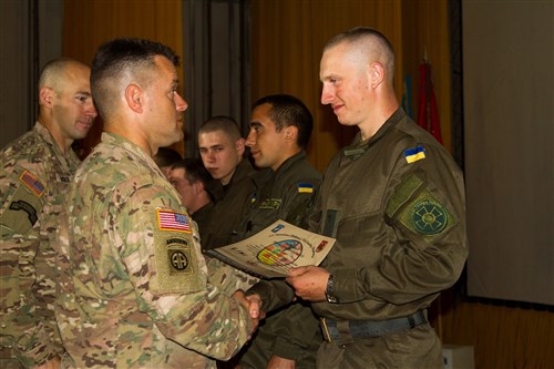 Lt. Col. Kyle Reed (foreground left), commander of 1st Squadron, 91st Cavalry Regiment, 173rd Airborne Brigade, presents an award to a soldier from the Ukrainian national guard's 3029th Regiment during a Fearless Guardian graduation ceremony June 13, 2015, in Yavoriv, Ukraine. Paratroopers from the 173rd Abn. Bde. are in Ukraine for the first of several planned rotations to train Ukraine's newly-formed national guard as part of Fearless Guardian, which is scheduled to last six months. (U.S. Army photo by Sgt. Alexander Skripnichuk, 13th Public Affairs Detachment)
