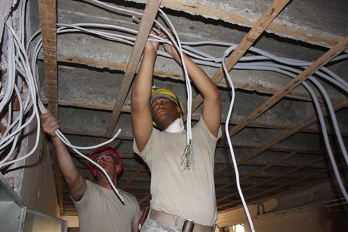 Sgt. Theo Calloway (right) works to run wiring with Master Sgt. Monty Stiltner Aug. 8, 2012, at the Svetozar Markovic Primary School in Kraljevo, Serbia. More than 30 Ohio National Guard members are in Serbia as part of the State Partnership Program, working alongside their counterparts in the Serbian 2nd Army Brigade to repair the school, which was damaged by an earthquake in late 2010. 