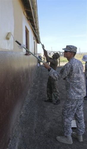 U.S. Army Pfc. Phillip Shin, 61st Multifunctional Medical Battalion, and South African Medical Health Services Pvt. Dumakude Sibonelo, paint the Masincedane Training Centre where military members teamed up to celebrate Mandela Day by volunteering at the school during a community engagement portion of Shared Accord 13 at Mzantsi Village, Republic of South Africa, July 26. Shared Accord is a biennial training exercise which promotes regional relationships, increases capacity, trains U.S. and South African forces, and furthers cross-training and interoperability. (Photos by Staff Sgt. Tamika Dillard, Sgt. Daniel Stoutamire and Spc. Taryn Hagerman)