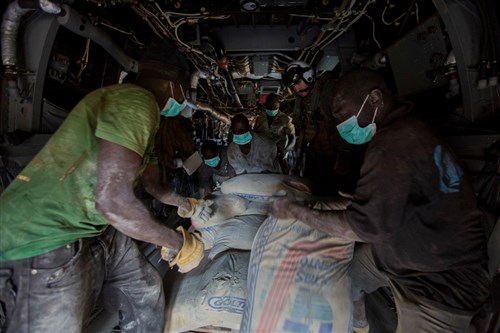 U.S. Navy Lt. Jeffery Fornadley, a flight surgeon with SPMAGTF Crisis Response – Africa, helps members of Samaritan's Purse, an international relief group, offload, from an MV-22B Osprey, bags of concrete that will be used to by health organizations to build Ebola Treatment Units, while in support of Operation United Assistance in Fish Town, Liberia, Nov. 21, 2014. United Assistance is a Department of Defense operation to provide command and control, logistics, training, and engineering support to U.S. Agency for International Development- led efforts to contain the Ebola virus outbreak in West African nations. (U.S. Marine Corps photo by Lance Cpl. Andre Dakis/SPMAGTF-CR-AF Combat Camera/Released) 