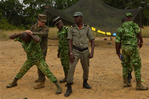 Lance Cpl. Mickey Anderson, a Marine with Special-Purpose Marine Air-Ground Task Force Africa 14, demonstrates detainee handling with members of a task force in Gabon, June 10, 2014. A team of 15 Marines and sailors trained with their Gabonese counterparts from the Agence Nationale des Parcs Nationaux and the Gabonese military and Gendarmerie to demonstrate tactics that could then be applied to combat all types of illicit activities, to include narcotics trafficking