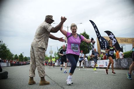 Mary Jo Betyak-Eisler, supervisor of the Community Counseling Program aboard Marine Corps Base Quantico, gets a high-five from former MCBQ Sgt. Maj. Gerald Saunders after completing the 2015 Marine Corps Half Marathon in October 2015. Photo courtesy Mary Jo Betyak-Eisler. 