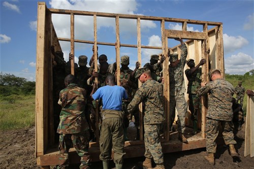 U.S. Marine combat engineers with Special-Purpose Marine Air-Ground Task Force Crisis Response-Africa, assist Uganda People’s Defense Force soldiers nail in one of the wall frames during a civil engineering exercise at Camp Singo, Nov. 19, 2015. The exercise helps the partner nations fortify their civil engineering skills while strengthening the bond between the two. (U.S. Marine Corps photo by Cpl. Olivia McDonald/Released)