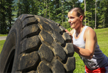 A woman working out pushing a tire