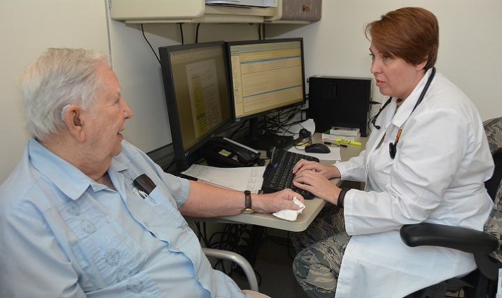 Air Force Officer Candidate Brandy Williams talks with Jimmie Locke during his appointment in the Internal Medicine clinic. Williams is a Physician Assistant student in Phase 2 of the Interservice Physician Assistant Program at Brooke Army Medical Center. (U.S. Army photo by Robert Shields)