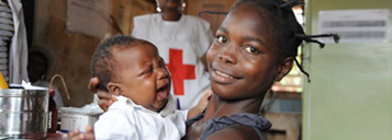 Little African girl holding a baby who just got a measles vaccination