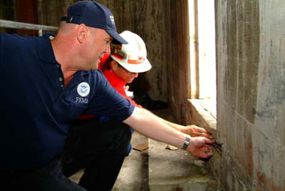 FEMA Mitigation Map Modernization Specialist Marshall Marik inspects for structural damage to the Hilo, Hawaii Fire Station with US Army Corps structural engineer Peter Lam after a recent series of earthquakes. November 13, 2006. FEMA Image.