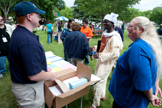 FEMA representative Richard McElhinney and SBA Public Information Officer Cynthia Cowell provide Fargo residents informational brochures translated into various languages.