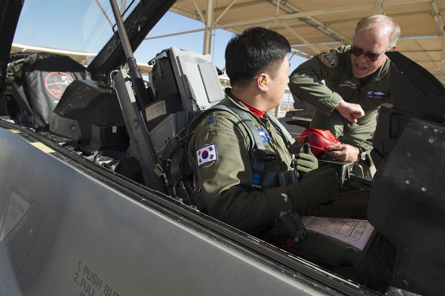 Evan Thomas (right), U.S. Air Force Test Pilot School instructor, gives a Republic of South Korea Air Force pilot some tips while sitting in an F-16 Nov. 3. (U.S. Air Force photo by Joseph Gocong)