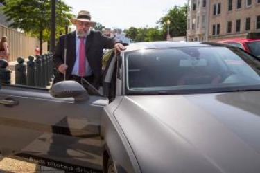 NCD Chair Clyde Terry leans against a gray Audi piloted car