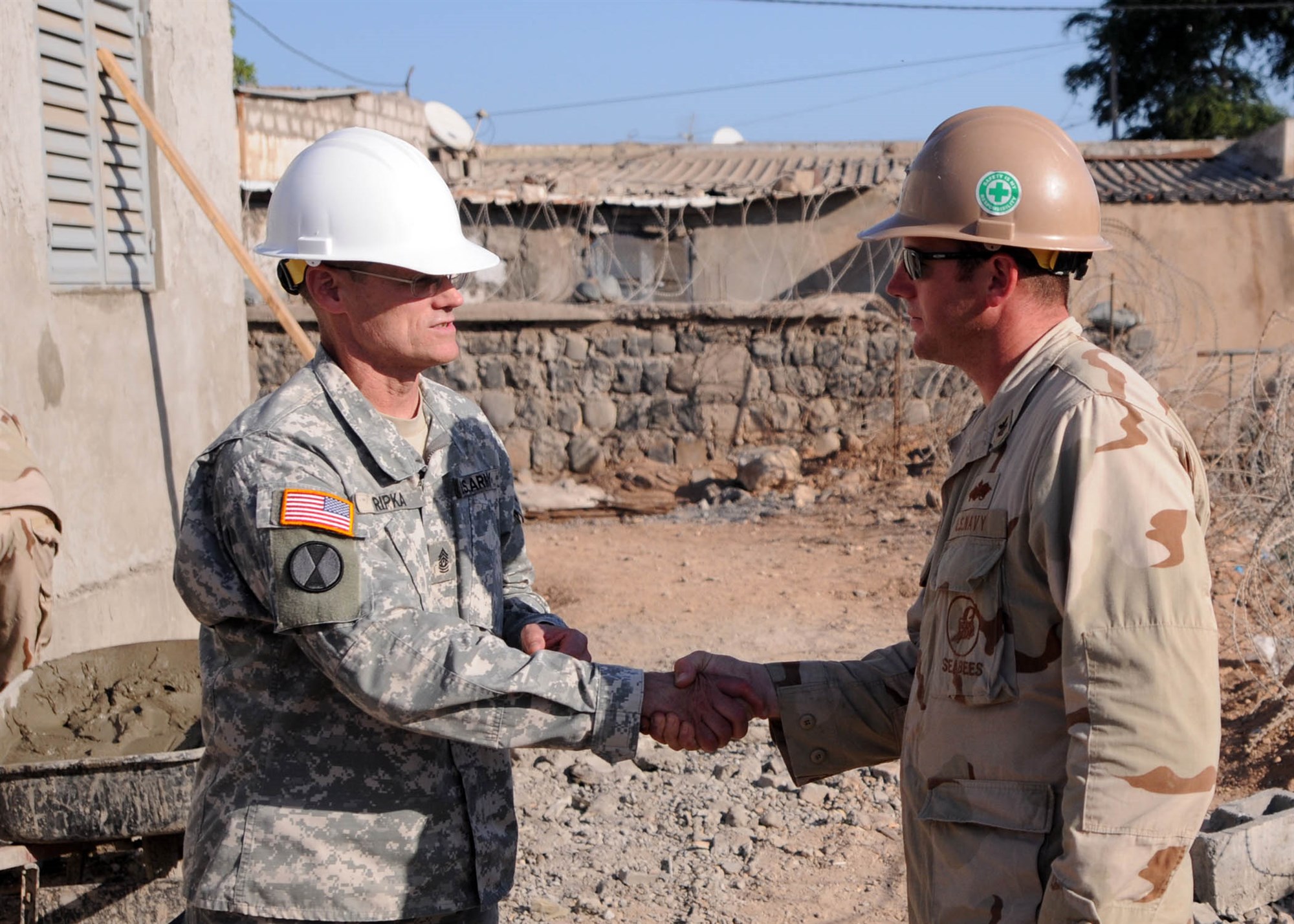 DJIBOUTI (Dec. 23, 2010) Command Sergeant Major (CSM) Mark S. Ripka, U.S. Africa Command&#39;s (U.S. AFRICOM) senior enlisted leader, presents Builder 1st Class Wayne Sperko, assigned to Naval Mobile Construction Battalion (NMCB) 74 Detail Horn of Africa (HOA), a CSM coin for his performance as a school project supervisor in Djibouti December 23, 2010. During his three-day visit with NMCB 74, Ripka toured project sites, attended a dinner with troops and held a non-commissioned officer (NCO) call where he shared his experiences concerning the role of NCOs in today&#39;s military.