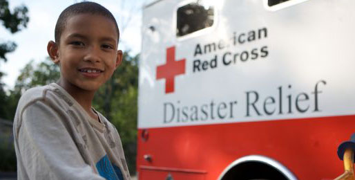 Little boy sitting in front of Red Cross emergency response vehicle